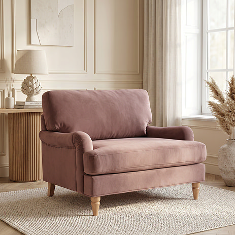 image of velvet blush pink snuggle chair with light wood legs in living room