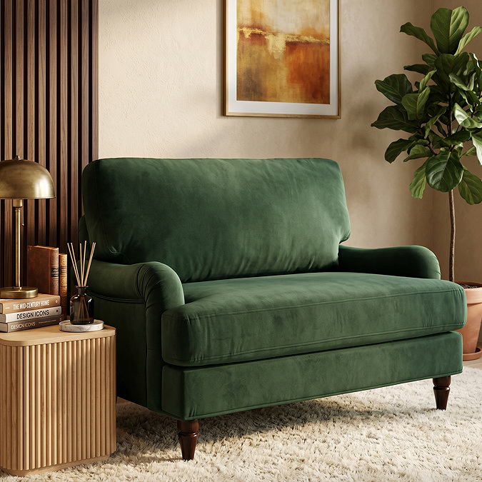 image of forest green velvet snuggle chair with dark wood legs on soft carpet