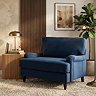 image of navy blue velvet snuggle chair with dark wood legs on cosy carpet