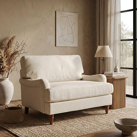 image of woven fabric beige snuggle chair with warm wood legs in living room on rug