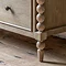close up on hand-crafted bobbin detail of legs on limed oak chest of drawers
