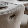 close up on back of dining chair upholstered in natural coloured fabric and with a divot to hold onto in order to more easily pull out chair