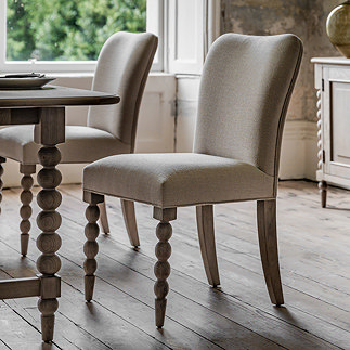 image of limed oak dining chair with bobbin front leg detail, tucked slightly under matching dining table