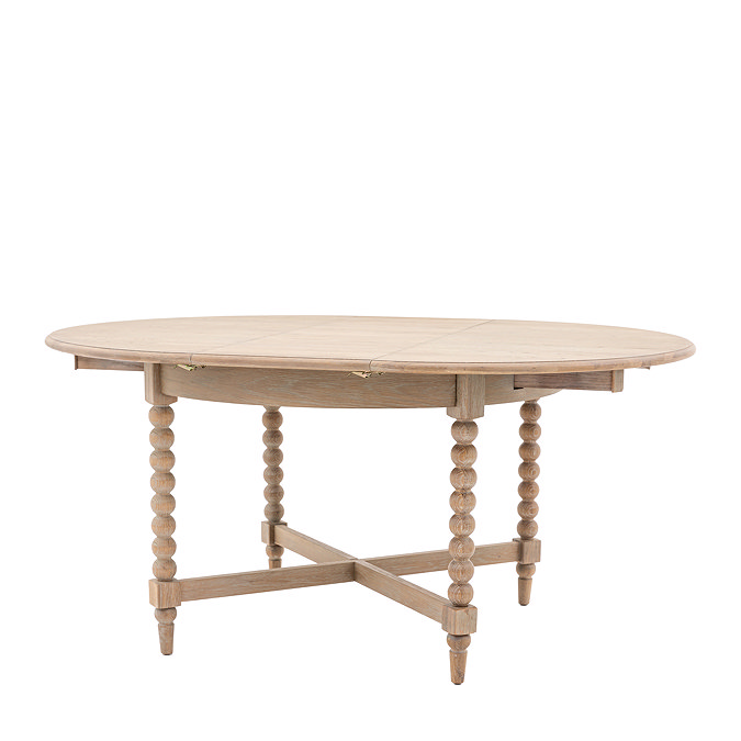 image cut out on white background of round limed oak dining table with crossed bobbin legs