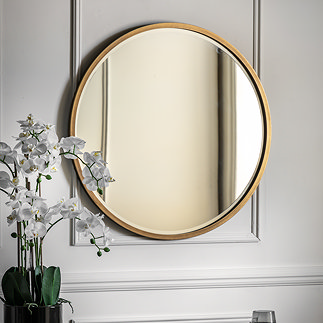 image of round antique gold mirror on grey wall