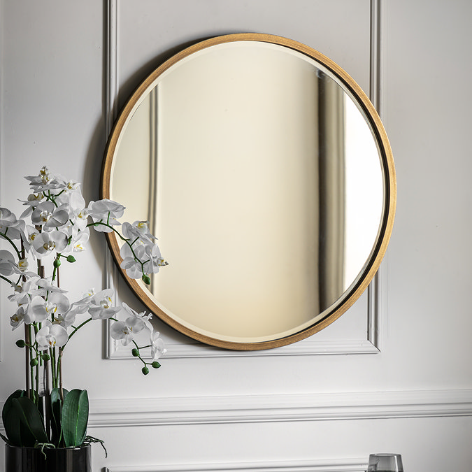 image of round antique gold mirror on grey wall