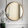 image of round antique gold mirror on grey wall