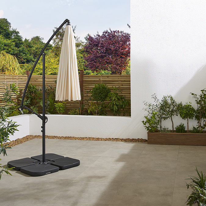 image of ecru parasol closed and hanging in empty sunny patio