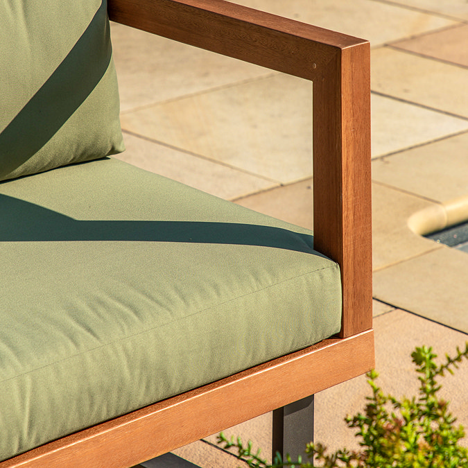 close up image of green eucalyptus cushion pad on modern wooden seat frame of outdoor sofa