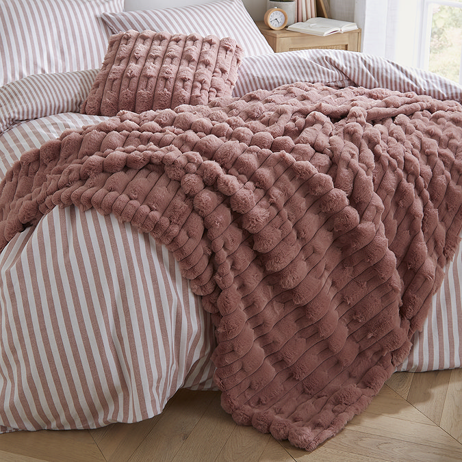 carved faux fur throw layed on a bed image 2