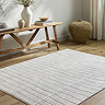 image of ivory rug with lined pattern on light wood flooring next to bench