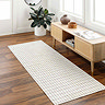 image of ivory runner with thin lined pattern in front of rattan sideboard on dark flooring in living room