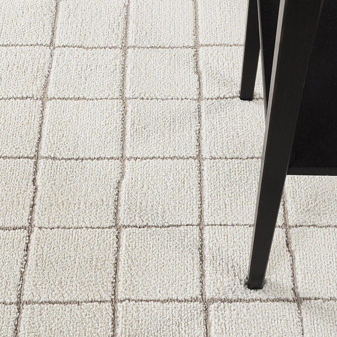 close up image on soft ivory rug with chair on top of it