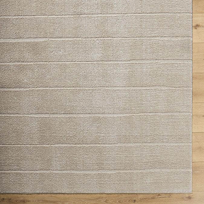 close up image on corner of beige striped rug