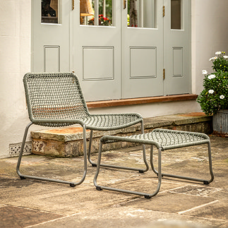 image of green woven rope garden chair with matching square footstool on patio