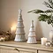 large ceramic tree next to medium ceramic tree on a sideboard, surrounded by cosy candles and a potted plant.