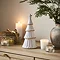 medium alora ceramic tree with star in a matte finish, displayed on a sideboard with cosy candles. 