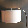 close up image of natural linen shade of curved nickel floor lamp, emitting soft warm glow