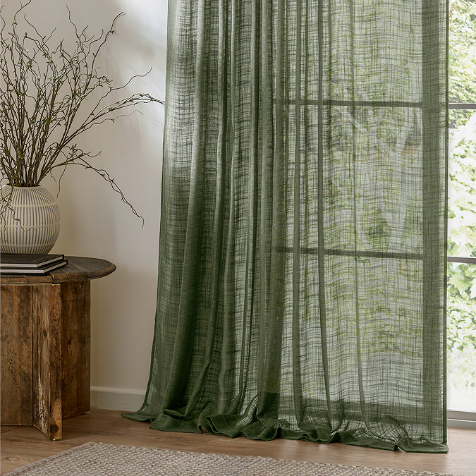 Cirrus Tab Top Sheer Curtain Panel in Forest Green close up in front of a window image