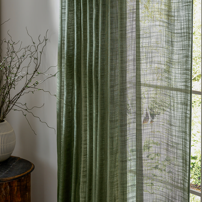 Cirrus Tab Top Sheer Curtain Panel in Forest Green close up in front of a window image