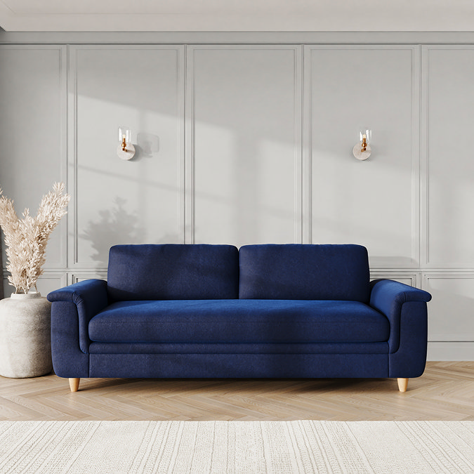 lifestyle image of grand sofa with sculpted arms and light oak feet, in indigo velvet fabric