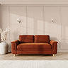 lifestyle image of large sofa with sculpted arms and light oak feet, in umber velvet