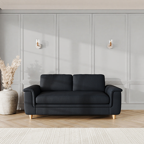 lifestyle image of large sofa with sculpted arms and light oak feet, in midnight chenille-velvet fabric
