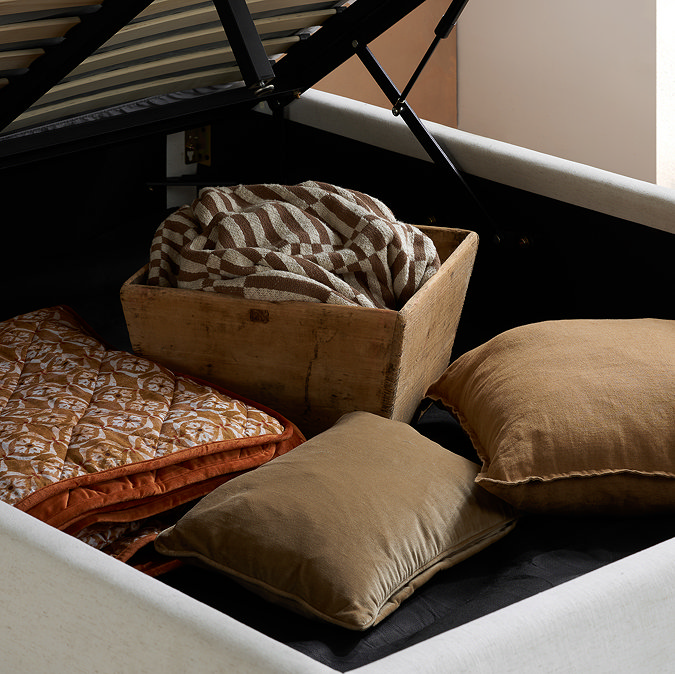close up on storage compartment of ottoman bed, with cushions inside