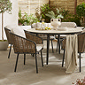 close up image of wicker chairs with black legs tucked under round sintered stone table