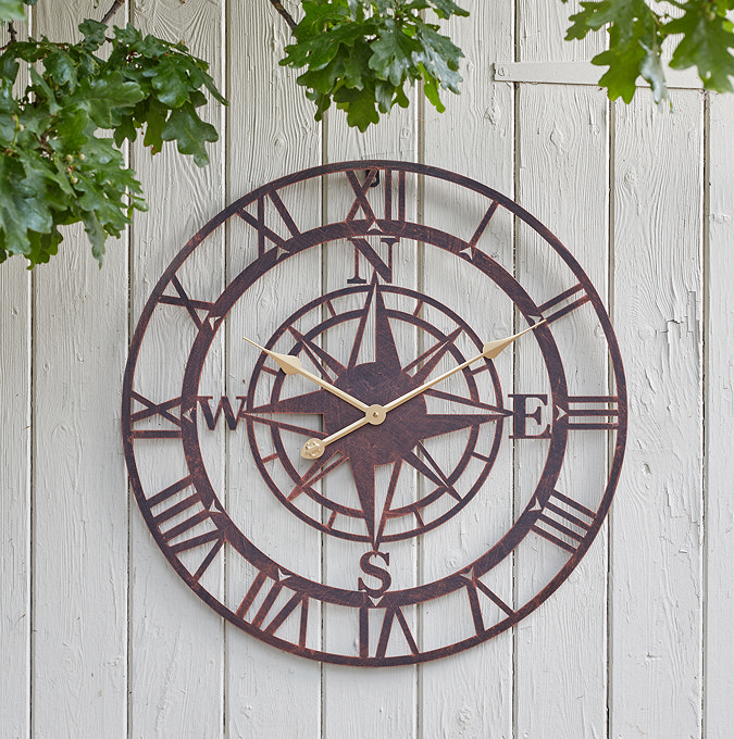 image of bronze round wall clock on white painted wooden fence