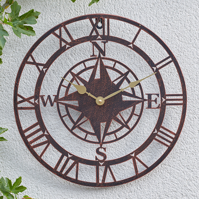 image of large bronze clock on white garden wall