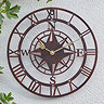 image of large bronze clock on white garden wall
