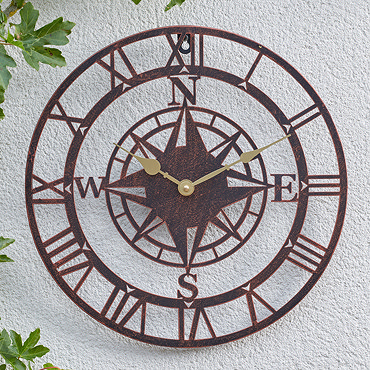 image cut out on white background of round bronze clock with central compass motif and gold hands