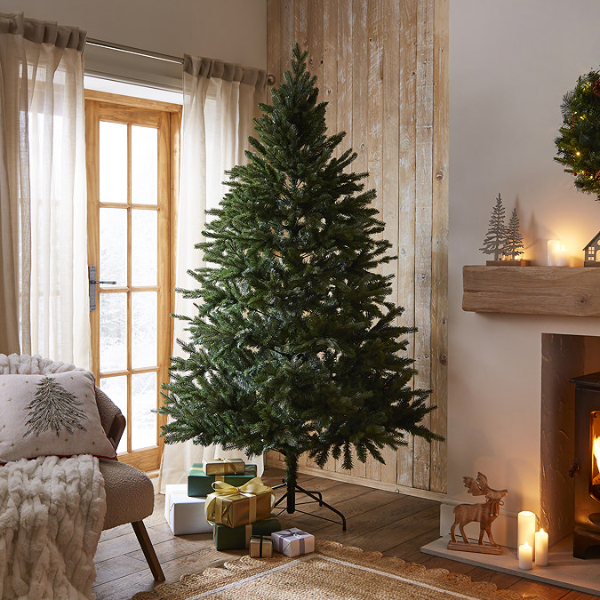 green coniferous spruce tree in the middle of a warmly lit living room