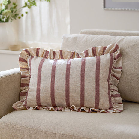rectangular cushion with pink stripes, sat on a cream sofa.