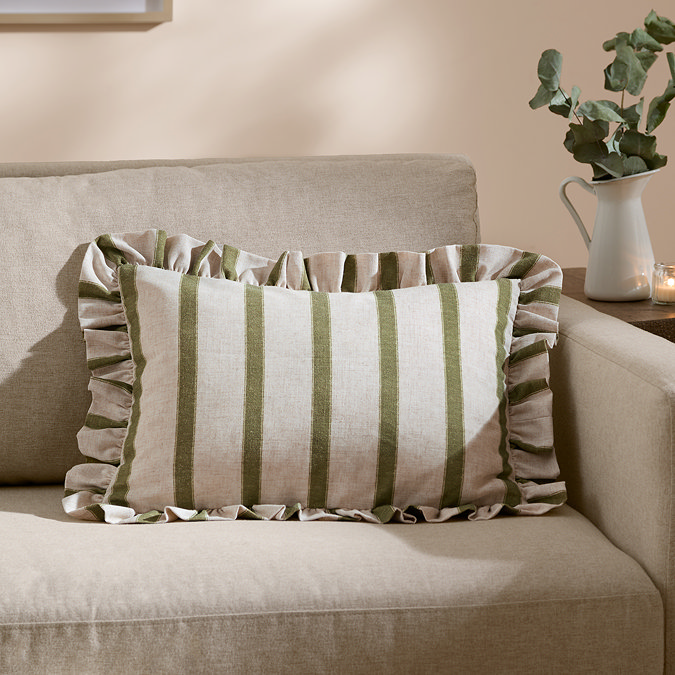 rectangular cushion with wide linen and narrow olive green stripes, sat on a cream sofa.