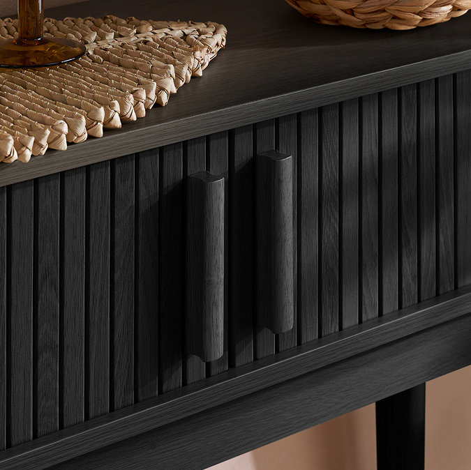close up on closed drawers of console table with fluted design and rectangular vertical handles