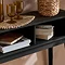 close up on inside of black console table with two storage sections, holding books