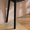 close up on left side thin legs of black console table