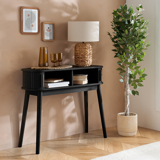 black console table with the drawers slid open to reveal two storage compartments inside, with books on them