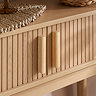 close up on fluted wooden texture of oak console table with sleek rectangular vertical handles