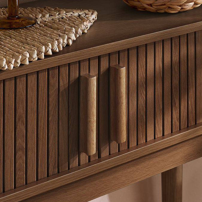 close up on closed drawers of walnut fluted console table with rectangular vertical handles