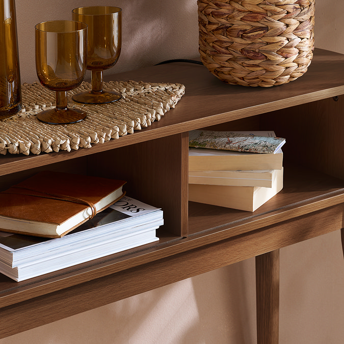 close up on inside of console table with two storage spaces holding books