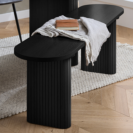 image of black smooth oval wood dining bench with fluted legs, on wooden flooring of dining room