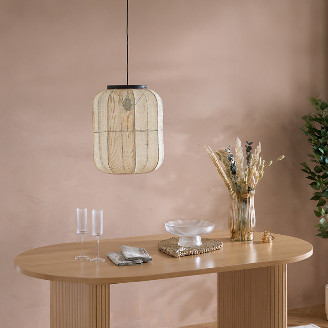 close up on smooth surface of oak dining table with faux fur plant and hanging rattan ligth above