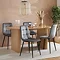 oval oak dining table with two stocky  fluted legs and four grey chairs around it
