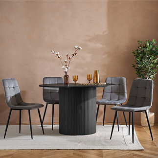 image of round black wood effect dining table with fluted cylindrical base, surrounded by grey chenille dining chairs