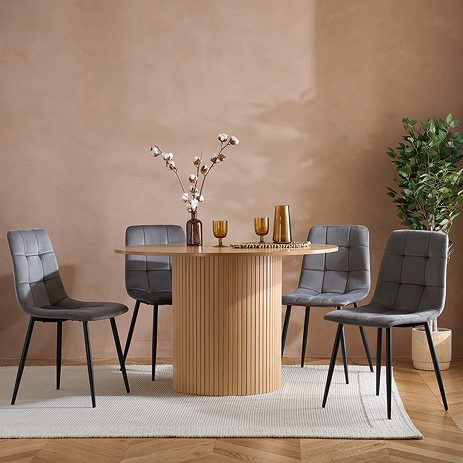 oval oak fluted dining table surrounded by 4 grey chairs
