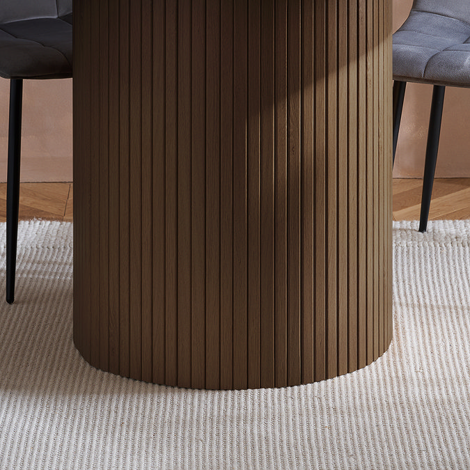 close up image of fluted cylindrical base of walnut brown dining table