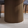 close up image of fluted cylindrical base of walnut brown dining table